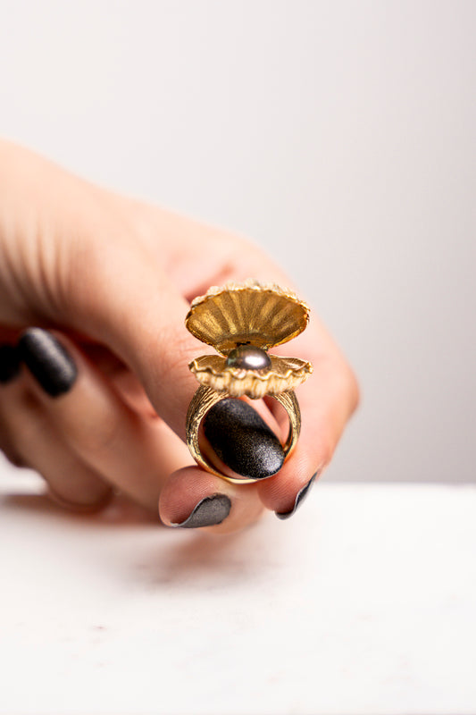 El anillo de perla negra iridiscente en oro