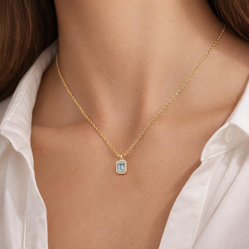 Colgante de topacio talla esmeralda y halo de diamantes en oro de 18 quilates