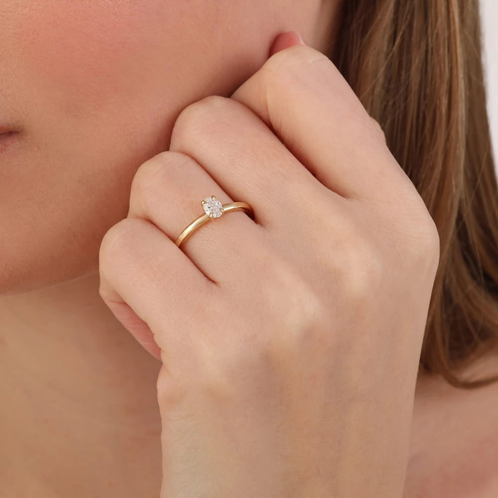 bague de fiançailles diamant ovale solitaire 0,52 carat portée au doigt en or jaune